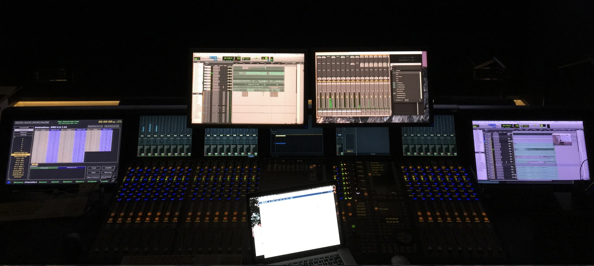 Dim mixing console and Pro Tools screens.